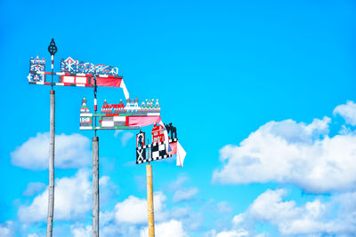 Low angle view of amusement park ride against blue sky