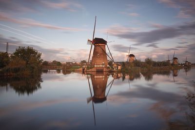 Traditional windmill against sky during sunset