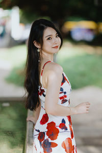 Portrait of young woman looking away while standing outdoors