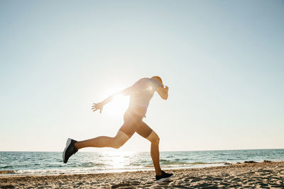 Full length of woman on beach against clear sky