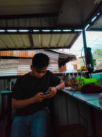 Man holding camera while standing at home