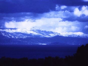 Scenic view of mountains against cloudy sky