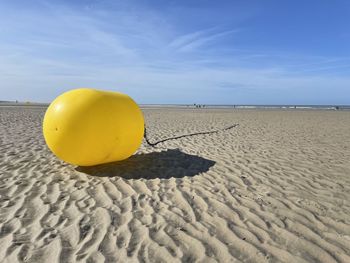 Yellow on beach against sky