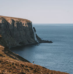 Rock formations by sea against sky