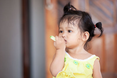 Close-up of cute baby girl eating fruit