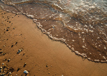 High angle view of pebbles on sea shore at beach