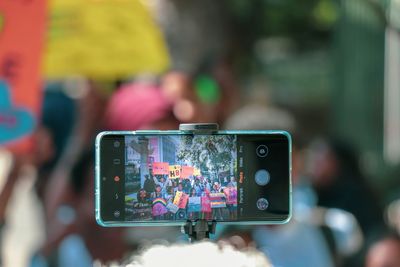 Close-up of smart phone photographing people