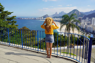 Young woman standing on railing in rio de janeiro, brazil