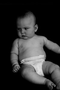 Cute baby boy against black background