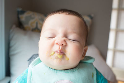 Close-up of cute baby with messy face sleeping at home