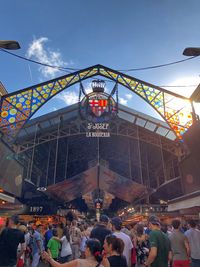 People at amusement park against sky