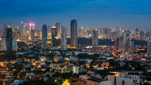 Aerial view of illuminated buildings in city against sky