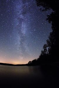 Scenic view of lake against sky at night