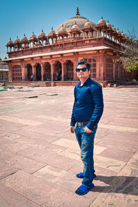 Full length portrait of man standing at historic building