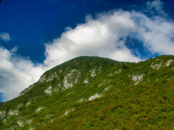 Low angle view of green mountains against sky