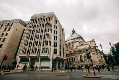 Buildings in city against cloudy sky