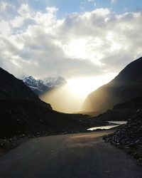 Road by mountains against sky