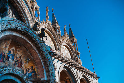 Low angle view of ornate building against blue sky