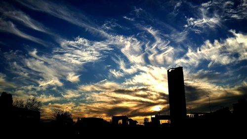 Silhouette of building against cloudy sky