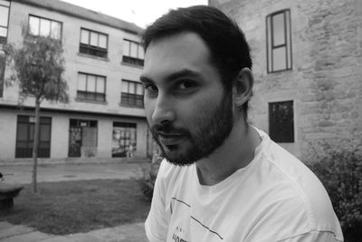 Portrait of man standing against building