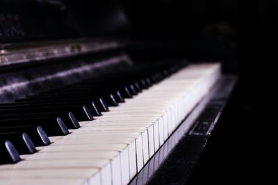 Close-up of piano keys against black background