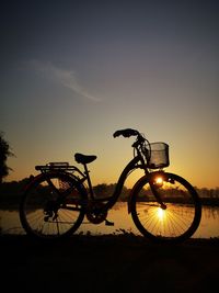 Silhouette bicycle against sky during sunset