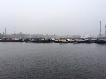 Boats moored in calm sea against sky