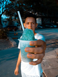 Portrait of boy holding ice cream outdoors