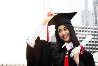 Young woman standing against building