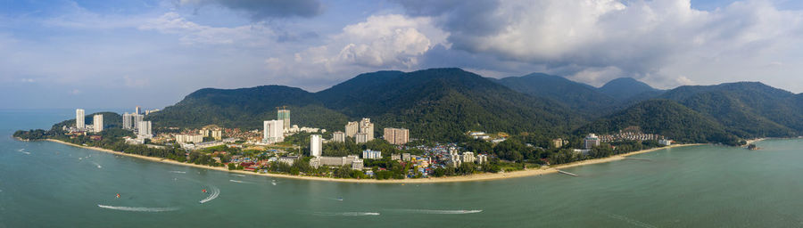 Panoramic view of city by sea against sky