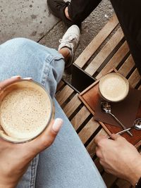 Low section of man holding coffee cup