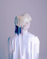 Rear view of woman standing against white background