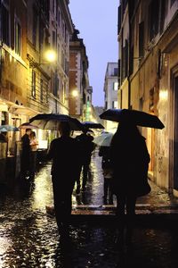 People walking on wet street during rainy season