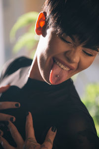 Close-up of playful woman sticking out tongue