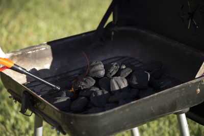 Cropped hand igniting barbecue grill