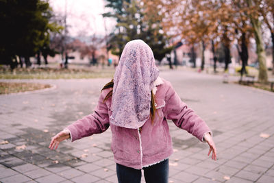 Rear view of woman walking on footpath