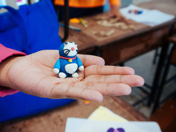 Close-up of hand holding small clay toy