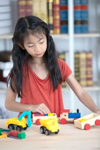 Cute girl playing with toy on table