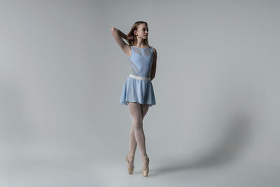 Ballet dancing against gray background