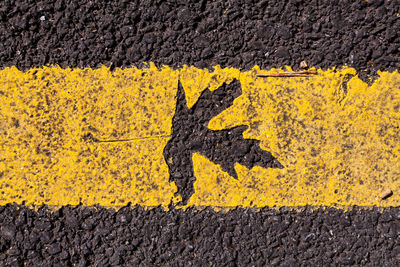 Close-up of yellow arrow symbol on road