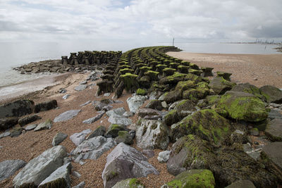 Scenic view of rocks on beach against sky