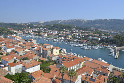 High angle view of townscape by sea against clear sky