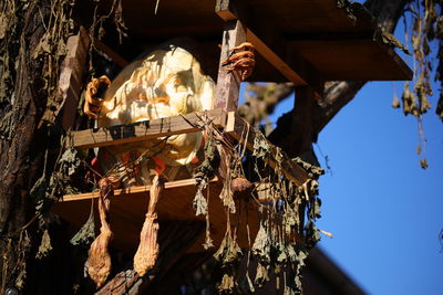 Low angle view of decorations hanging on tree against sky