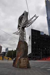 Low angle view of statue against sky in city