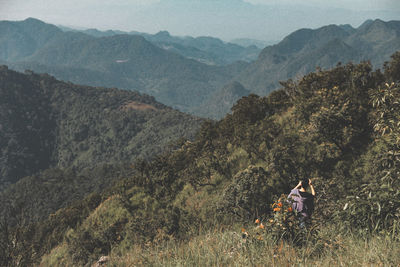 People on mountain range against sky