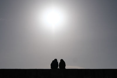 Silhouette people standing against sky