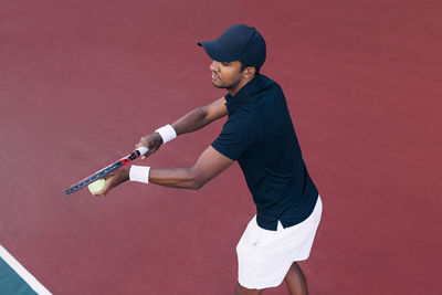 Side view of man playing tennis