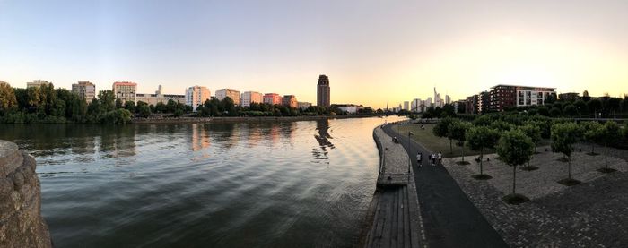 Scenic view of river by buildings against sky