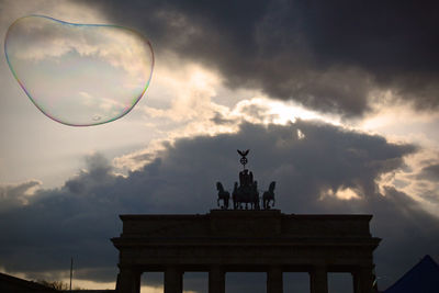 Low angle view of monument against cloudy sky