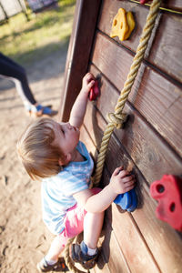 Side view of boy climbing wall